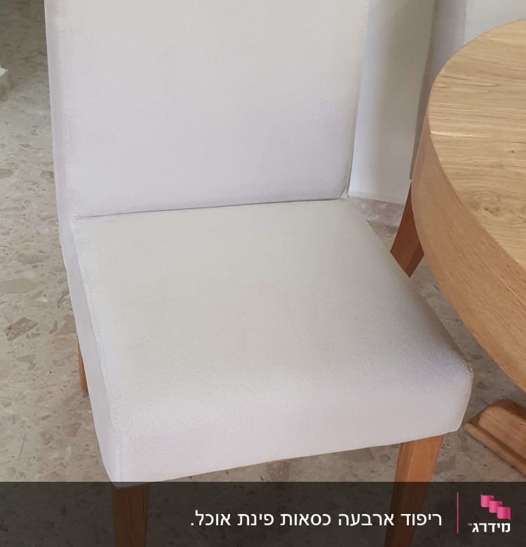 כיסא מרופד ליד שולחן עץ עגול